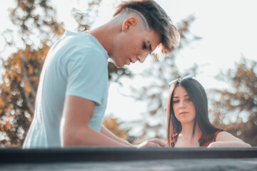 Chavales jovenes cocinando una barbacoa al aire libre en un parque junto a los arboles