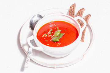 Red puree soup with tomato, greens, and bread