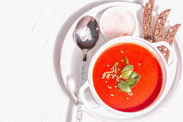Red puree soup with tomato, greens, and bread