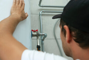 Plumber screwing nut of pipe in the heating system in the boiler room