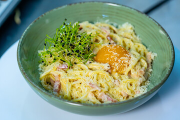 Pasta carbonara with parmesan and yolk. Italian cuisine. Cropped view. Italian kitchen and culinary concept