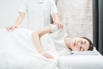 エステサロンでマッサージを受ける若い女性