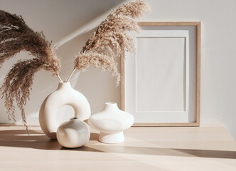 frame mockup on beige table, modern beige ceramic vases with dry grass and sunlight shadow.Neutral...
