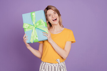 Photo of young attractive woman happy positive smile shake present gift box birthday isolated over purple color background