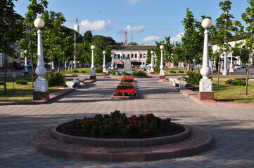 Obraz premium Panorama of the city square. Flowerbed and white lanterns in the park. Summer, background.