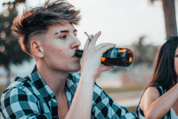 Hombre joven disfrutando de un día de vacaciones en una barbacoa junto con amigos bebiendo cerveza...