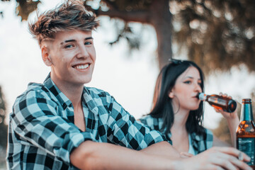 Pareja de novios disfrutando de una velada en una fiesta con amigos en un picnic al aire libre de...