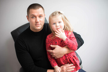 Emotional portrait of father and daughter on a gray studio background