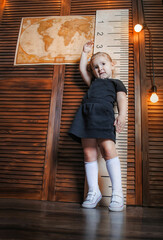 a girl schoolgirl of American appearance sits on the books, behind her back is a blackboard for the...