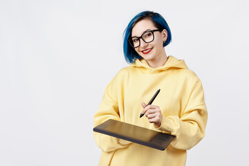 A female designer in yellow hoody holding a graphic tablet.
