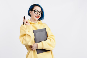 A female designer in yellow hoody holding a graphic tablet.