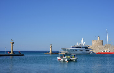 Rhodes, Greece famous Mandraki Marina with sculptures and fortress St Nicolas and boats