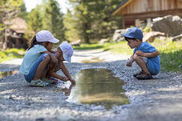 Kids playing outside in a puddle of water