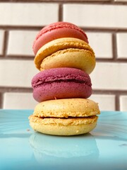 colorful macaroons on blue plate, brick wall