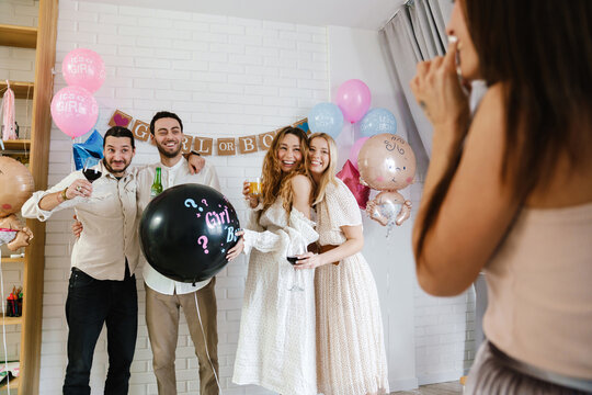 Group of happy friends at a gender reveal baby shower