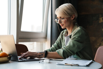 Middle aged blonde woman with short hair studying