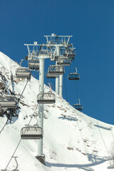 ski lift at a ski resort high in the mountains. chairlift for skiers and snowboarders. high-quality poster - the opening of the ski season