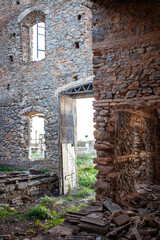 interior de una casa antigua abandona y en ruinas donde se ven las ventanas y la puerta y el campo en el exterior