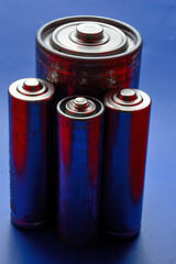 several different batteries on a blue background. close-up.