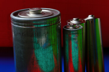 several multi-colored batteries on a blue-red background. close-up.