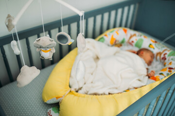Musical carousel at baby bed with baby sleeping. 