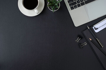 Black leather office desk table. Workspace with keyboard of laptop computer and pen, equipment...