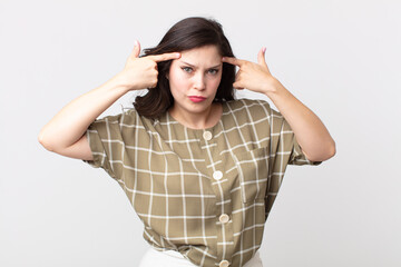 pretty woman with a serious and concentrated look, brainstorming and thinking about a challenging...