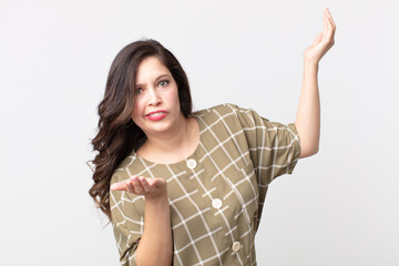 pretty woman shrugging with a dumb, crazy, confused, puzzled expression, feeling annoyed and...