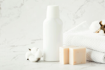 Empty white cosmetic container, jar, soap and towels on shelf in bathroom. A set of cosmetics for face and body care. Copy space.