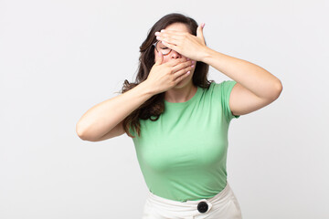 pretty woman covering face with both hands saying no to the camera! refusing pictures or forbidding...