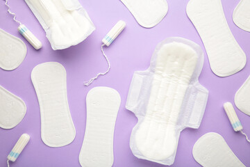 Menstrual tampons and pads on a purple background. Menstruation cycle. Hygiene and protection.
