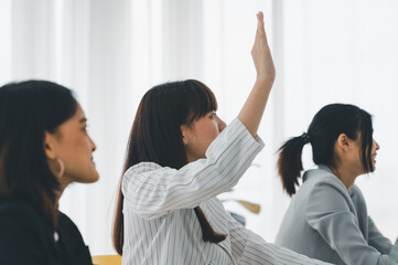Business raises his hand to raise questions about the meeting content with the presenter in the...
