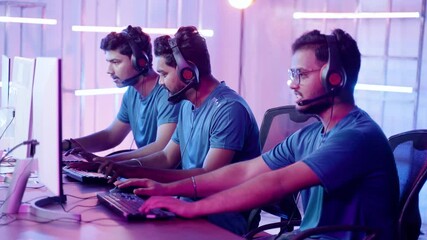 Team of gamers upset over loss of game while playing on esports tournament on neon stage background.