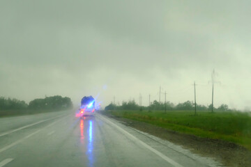 Blurred Defocused Emergency light of a rescue vehicle on the street in the evening, it's raining. This is in the fall