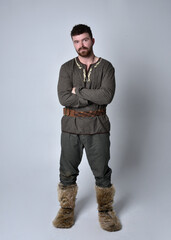 Full length  portrait of  young handsome man  wearing  medieval Celtic adventurer costume. ...