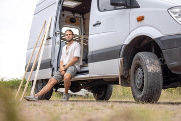 Man sitting in the doorway of his camper van