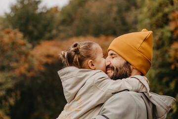 young, stylish bearded father walking with his little daughter in nature at sunset. Family photos of father and one child.