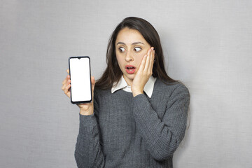 Mujer sorprendida sosteniendo celular. Fondo blanco