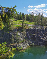 View of the picturesque rocky shores and the emerald water of the Marble Canyon in the Ruskeala Mountain Park on a sunny summer day.