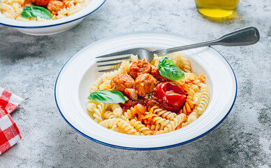 Pasta with meatballs and tomatoes on concrete background