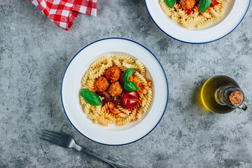 Pasta with meatballs and tomatoes on concrete background