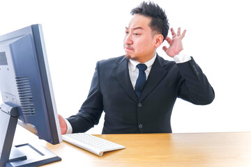 パソコンの前で憤慨するビジネスマン