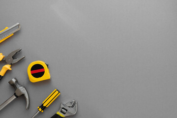 Flat lay composition with construction and home repair tools tools on grey background, space for...