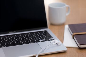 ノートパソコンと手帳とマグカップ