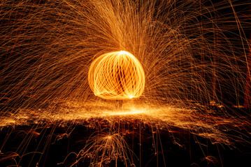 Orange circle moving light fire trails on black background.