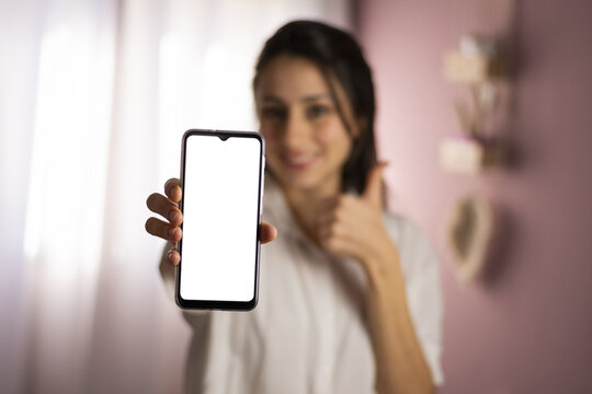 Mujer sosteniendo y mostrando celular.
