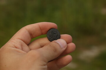 Ancient copper coin in hand