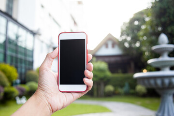 Connection technology background concept, Close up of male hands holding phone with isolated black screen in the garden. 