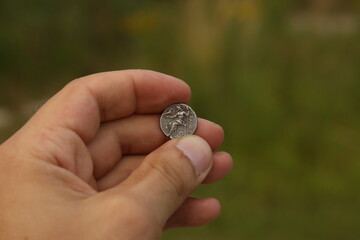 Silver coin of ancient Greece in hand
