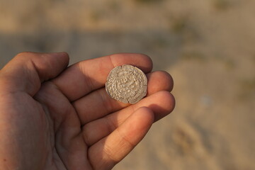 Medieval silver arab coin in hand